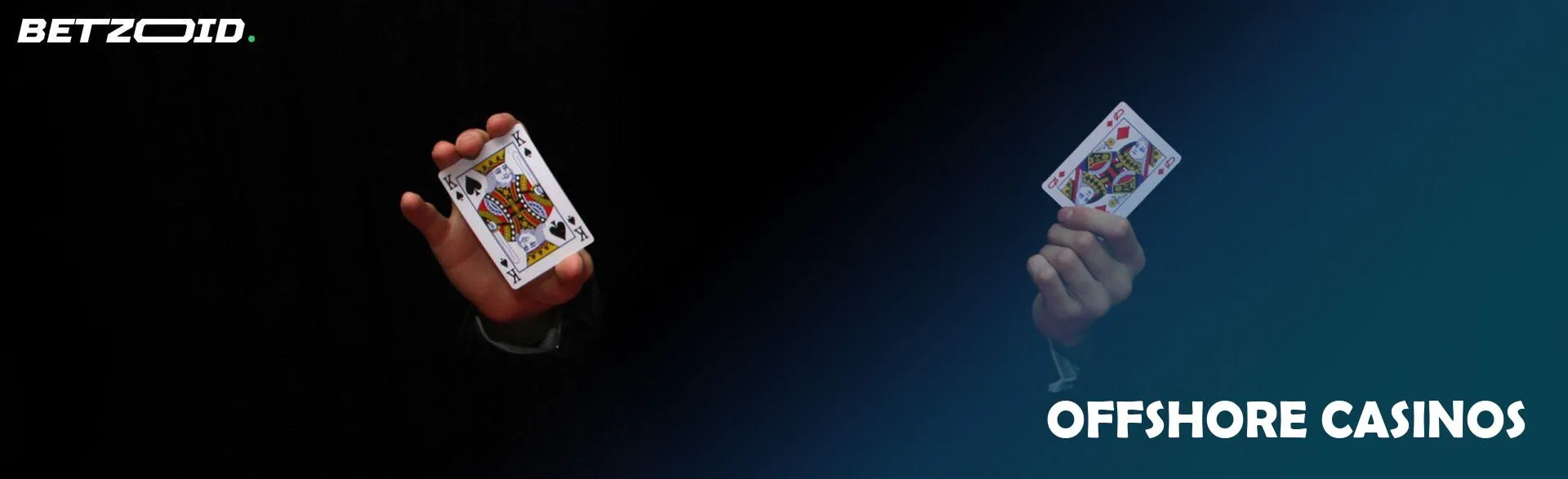 A man is holding two cards on a dark background.