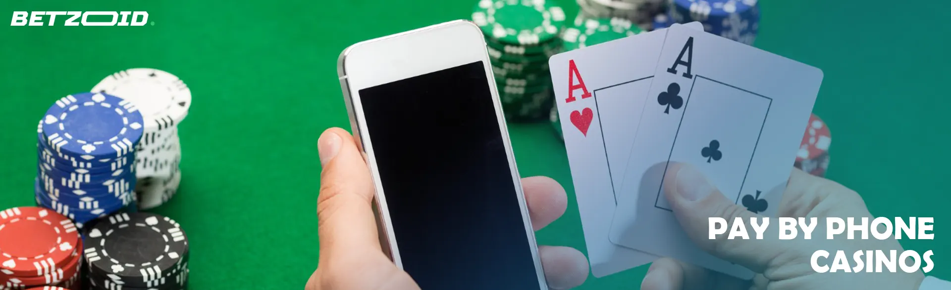 A player holds cards and a smartphone next to casino chips.