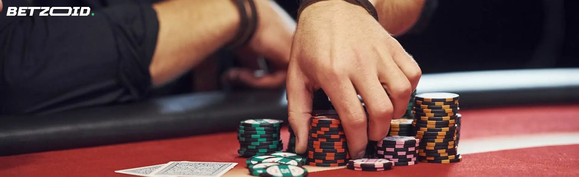 A player holds chips on the casino table.
