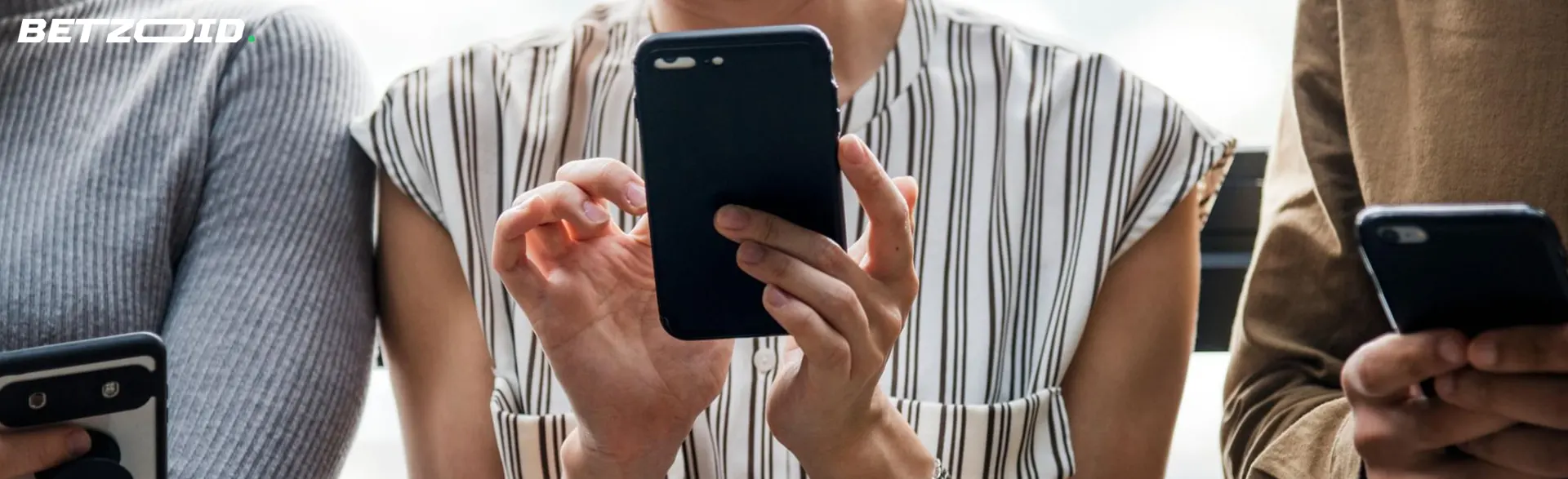 Kilka osób ze smartfonami w rękach.