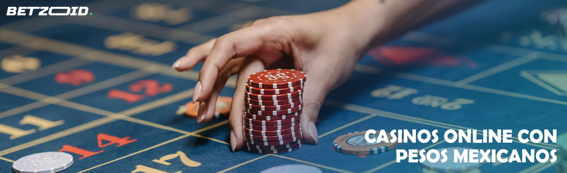 Una mano sostiene una pila de fichas en una mesa de ruleta.