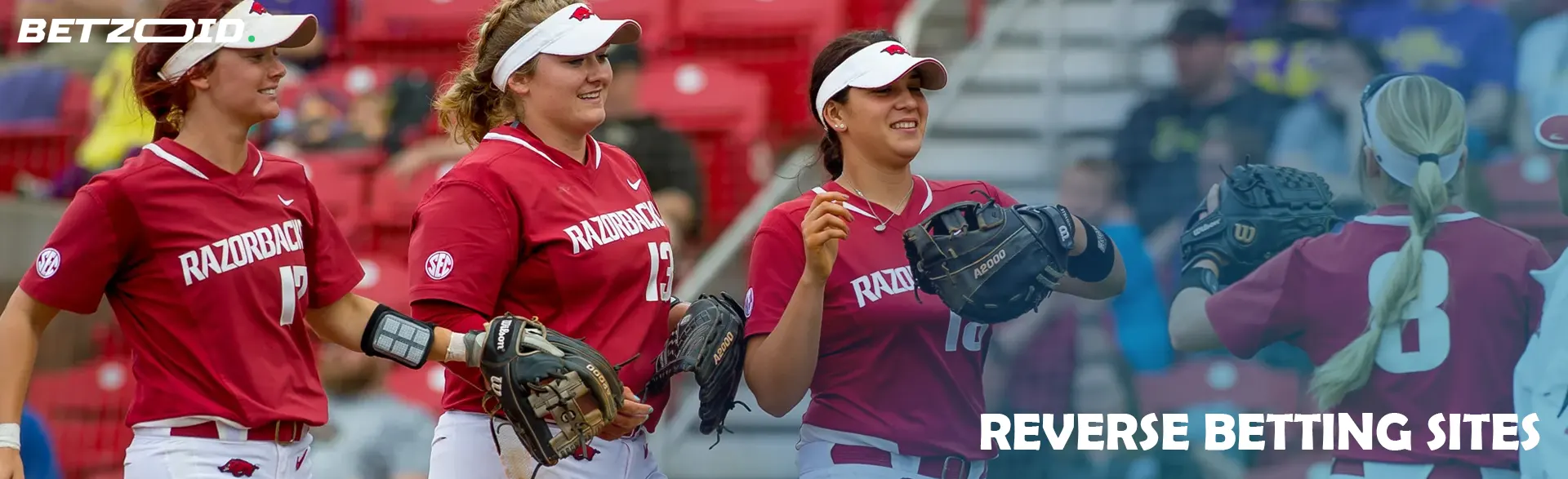 Women softball players in red uniforms on the field.