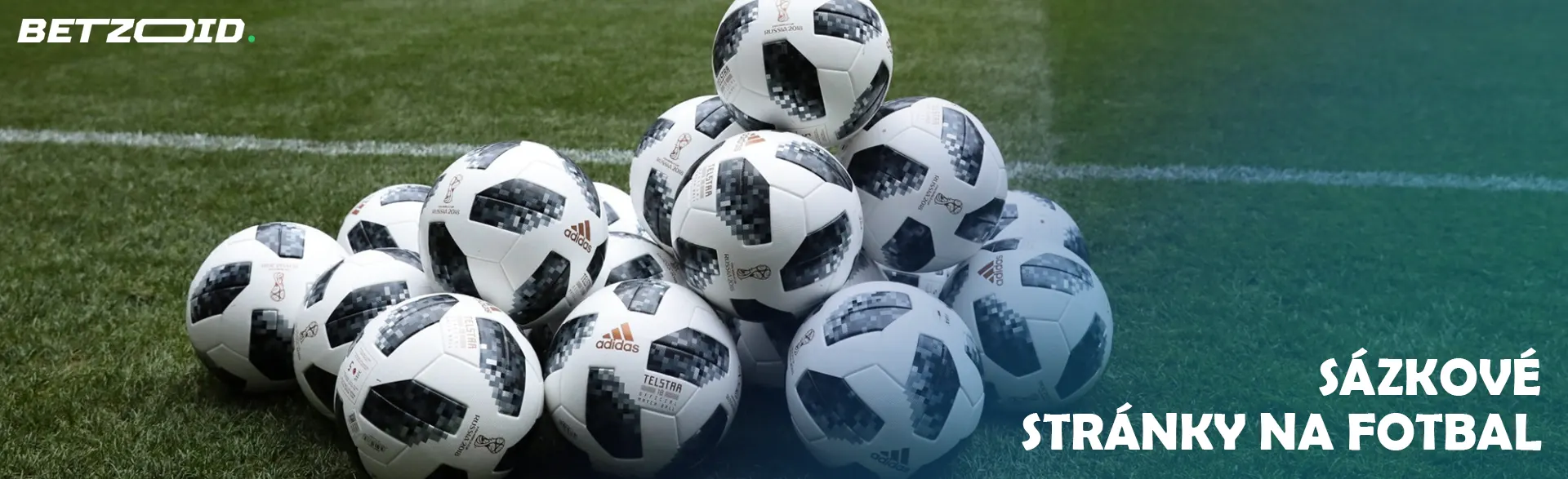 Hromada fotbalových míčů na hřišti.