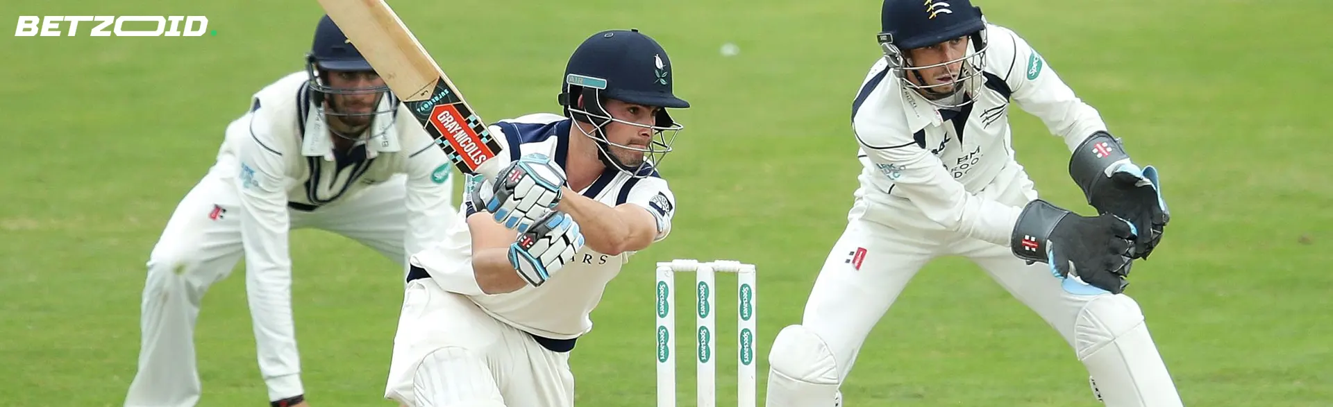 Hráč kriketu zasáhne míč.