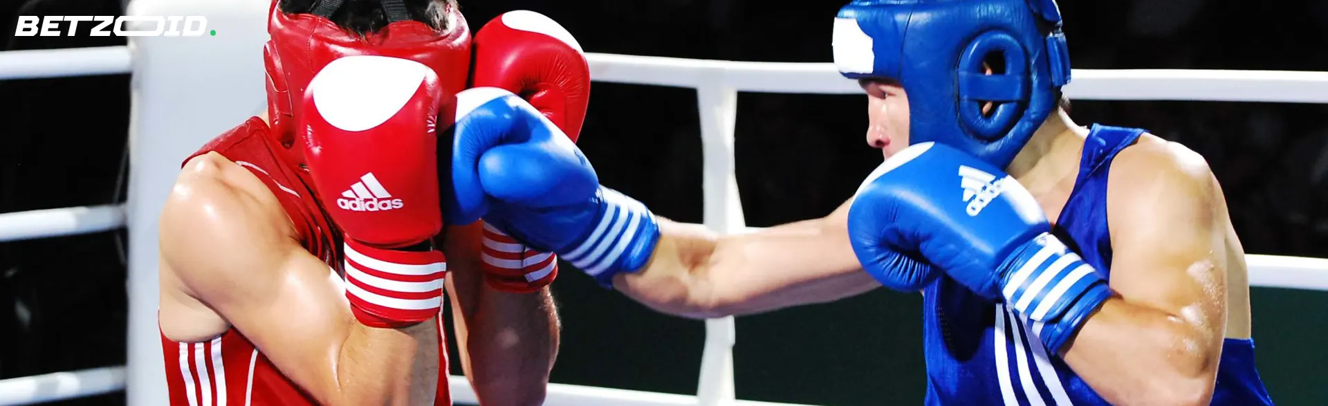 Due pugili sul ring durante un combattimento, uno dei quali sta sferrando un pugno.