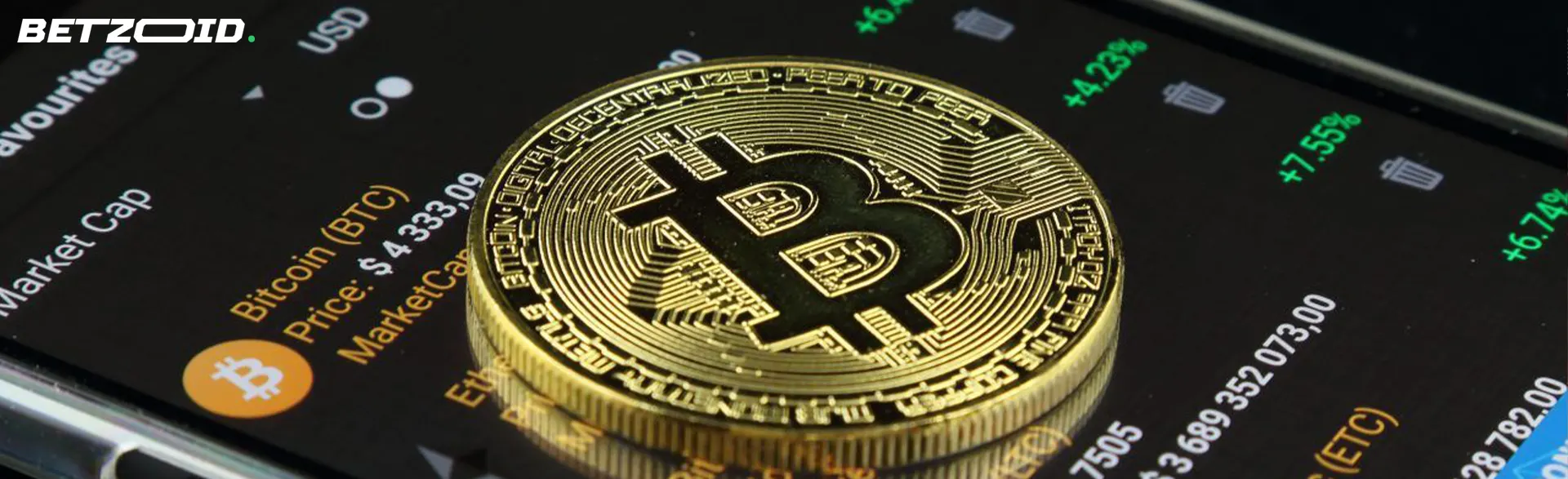 La moneda de oro Bitcoin se encuentra en la pantalla del teléfono inteligente.