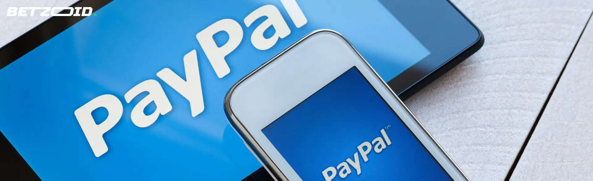 Logotipo de PayPal en tableta y teléfono inteligente.