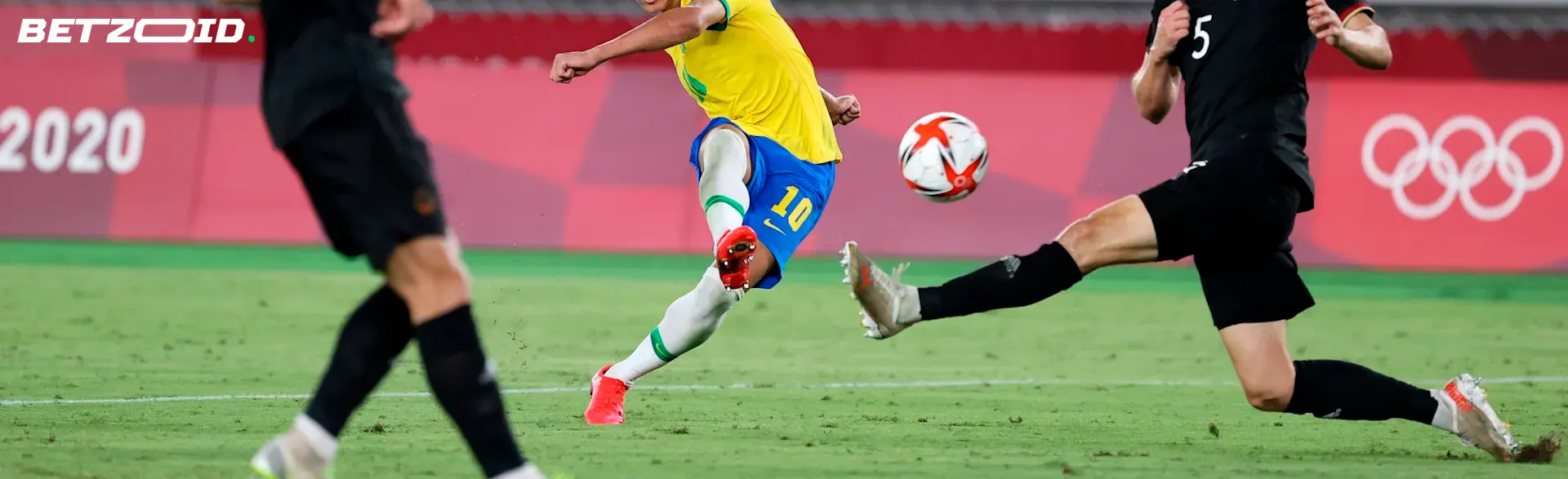 Player kicking soccer ball in match.