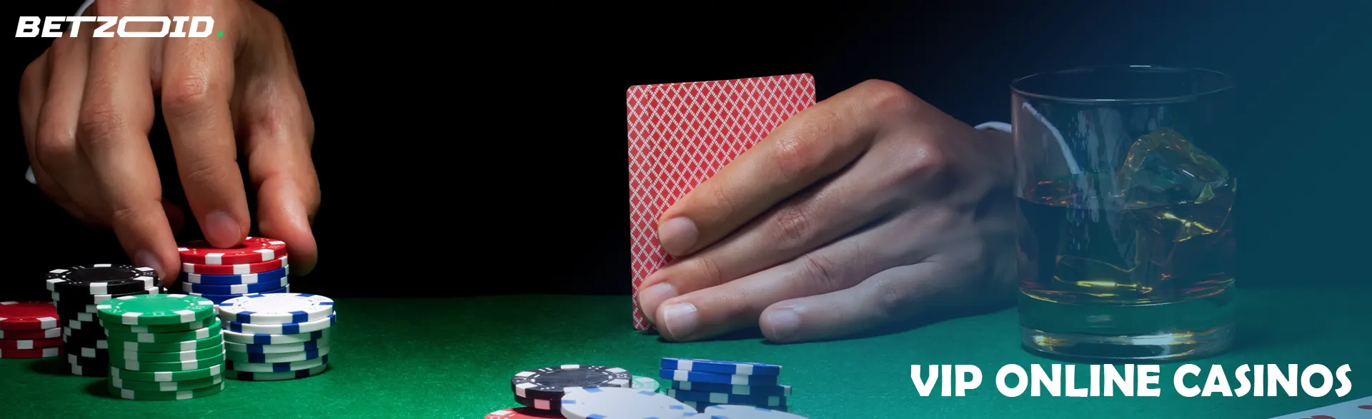 A player holds cards next to casino chips and a drink in a glass.