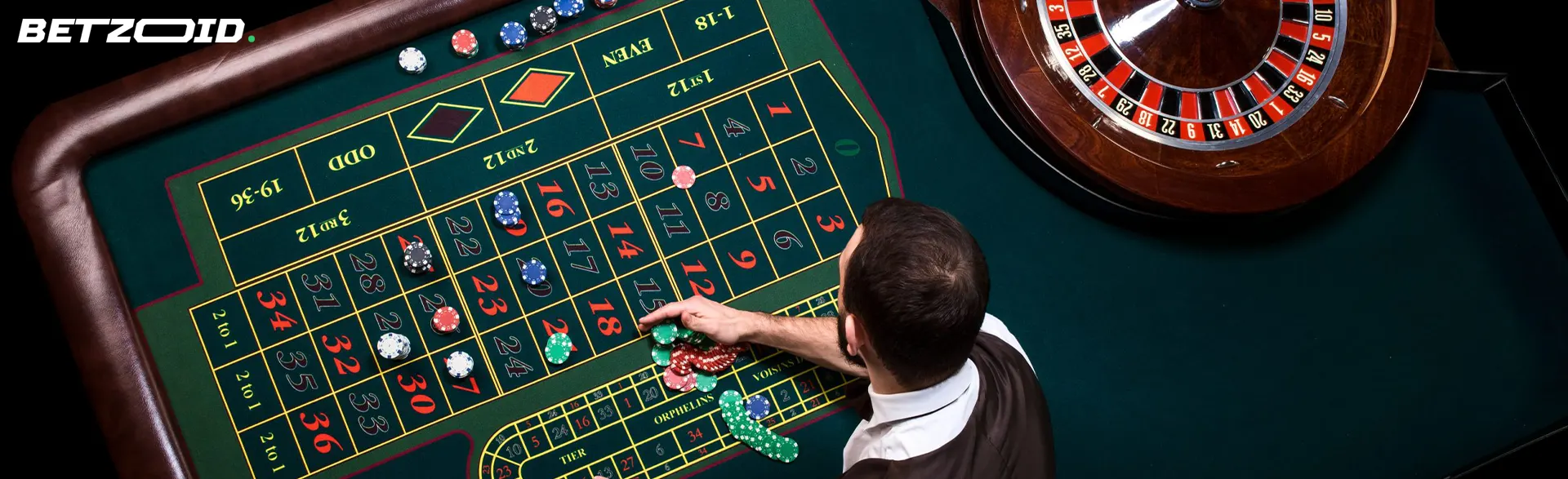 Vista dall'alto di un croupier che sistema fiches su un tavolo da roulette verde in un casinò.