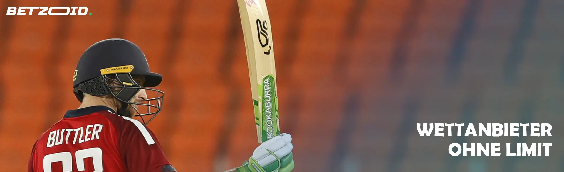 Ein Cricketspieler mit Schläger vor dem Hintergrund leerer Tribünen.